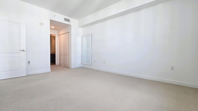 unfurnished room featuring light carpet