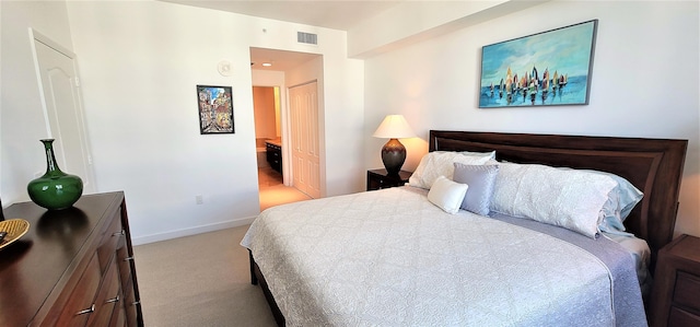 bedroom featuring light colored carpet and connected bathroom