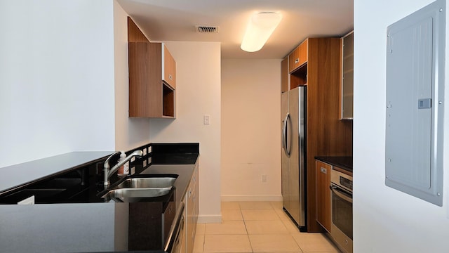 kitchen with sink, light tile patterned floors, stainless steel appliances, and electric panel