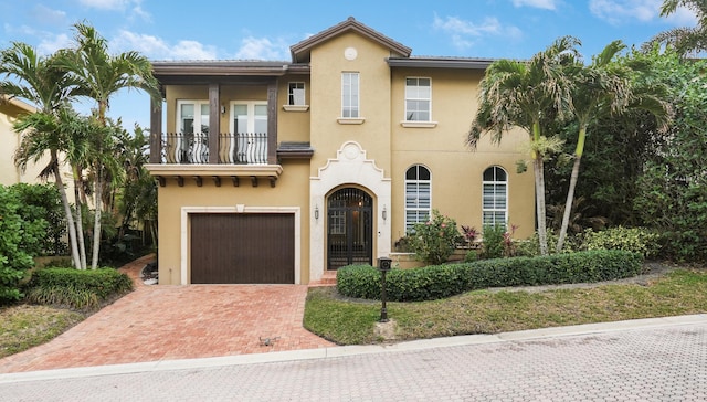 mediterranean / spanish-style house featuring a balcony and a garage