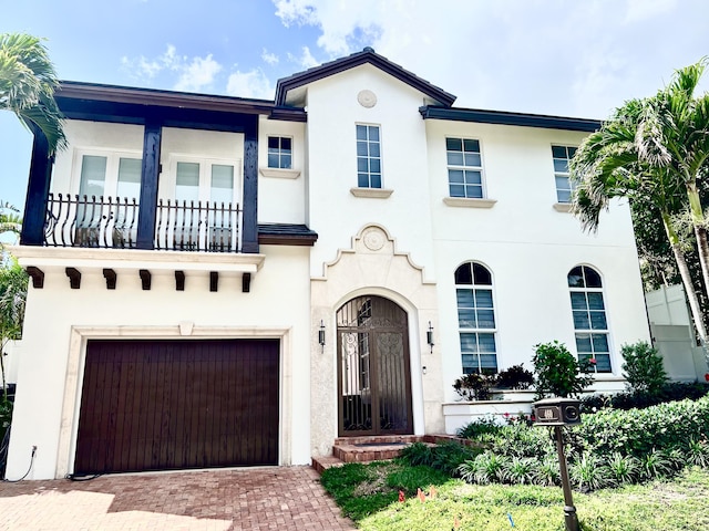 460 Surfside Ln, Juno Beach, FL 33408 - view of front of property featuring a balcony, stucco siding, an attached garage, and decorative driveway