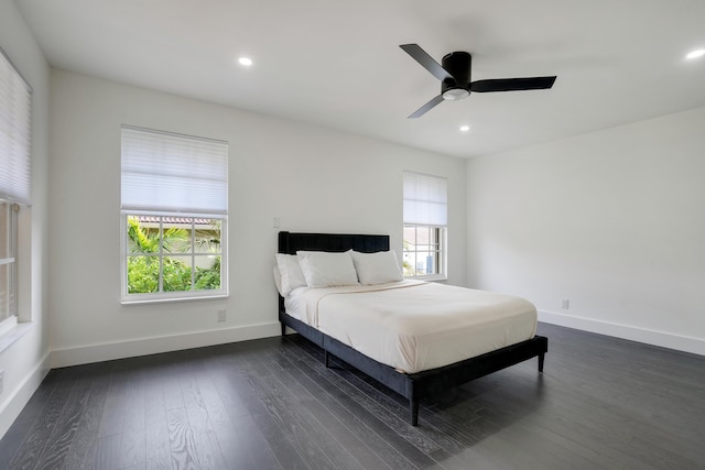 bedroom with dark hardwood / wood-style flooring and ceiling fan