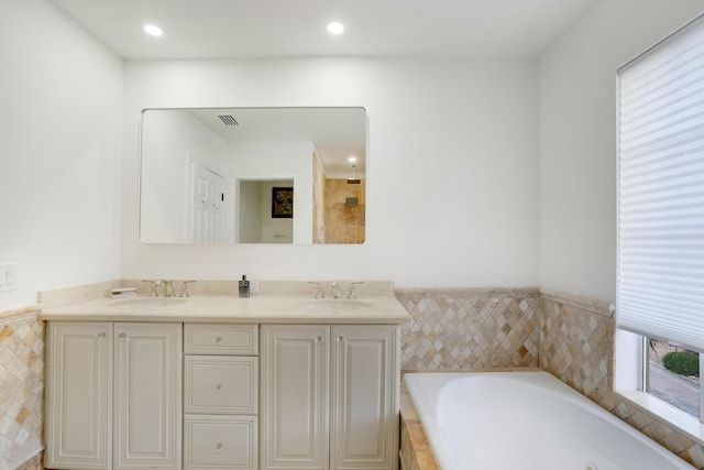 bathroom featuring vanity and a bath