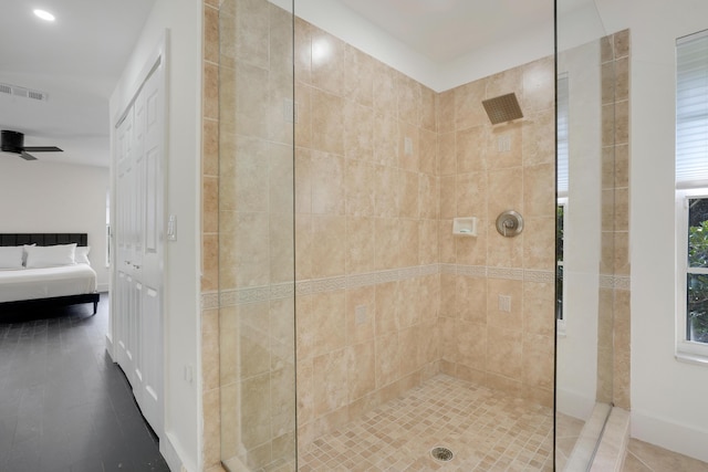 bathroom with tiled shower and ceiling fan