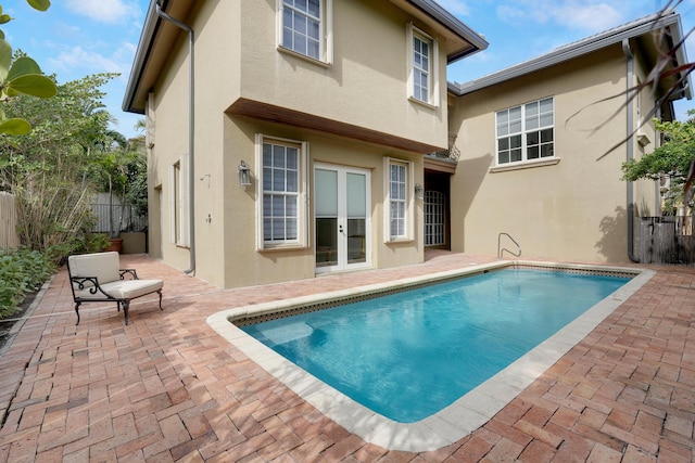 back of house featuring a fenced in pool, a patio area, and french doors