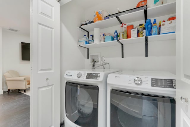 laundry room featuring wood-type flooring and washer and clothes dryer