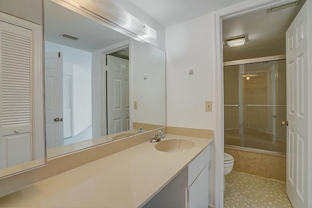 full bathroom featuring enclosed tub / shower combo, vanity, and toilet