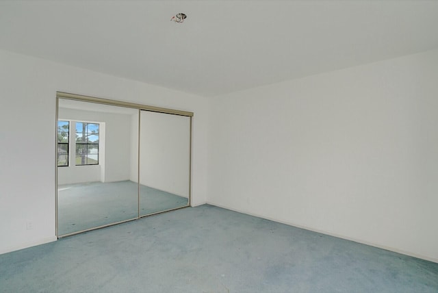 unfurnished bedroom featuring a closet and carpet flooring