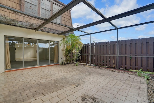 view of patio featuring glass enclosure