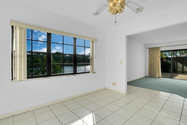 spare room featuring ceiling fan, plenty of natural light, and light tile patterned flooring