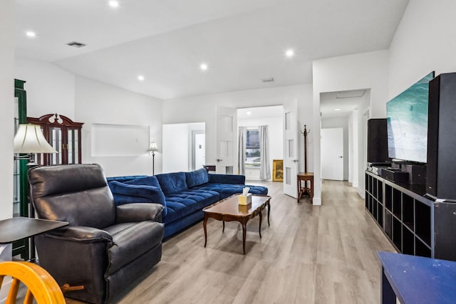 living room featuring light hardwood / wood-style flooring and vaulted ceiling