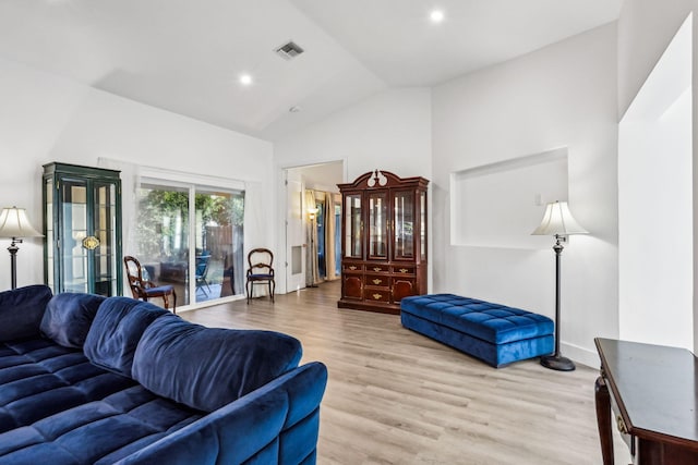 living room featuring light hardwood / wood-style floors and high vaulted ceiling