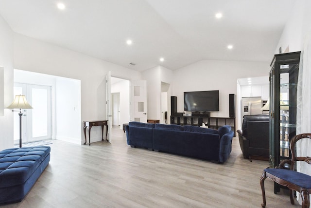 living room with french doors, light wood-type flooring, and lofted ceiling