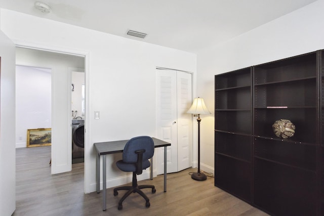 office featuring washer / clothes dryer and hardwood / wood-style flooring