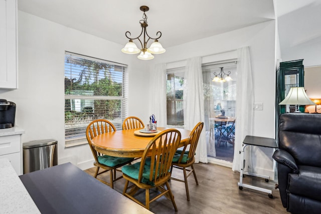 dining room with dark wood-type flooring and a notable chandelier