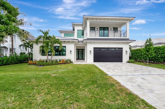 view of front of property featuring a front lawn, a garage, a balcony, and french doors