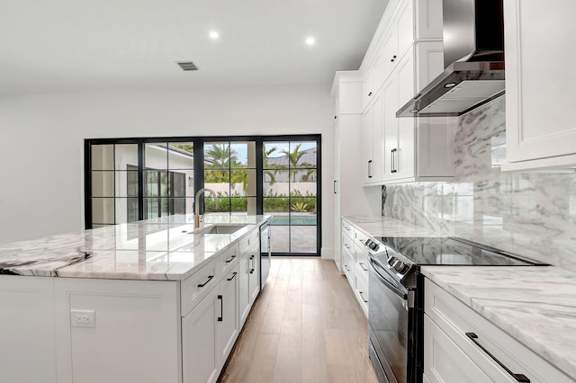 kitchen featuring white cabinets, sink, wall chimney range hood, and stainless steel appliances