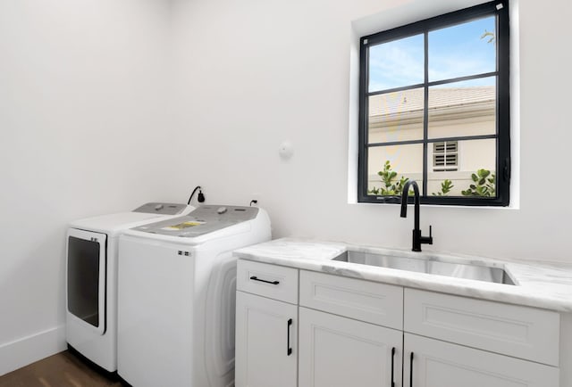 laundry area featuring cabinets, separate washer and dryer, and sink