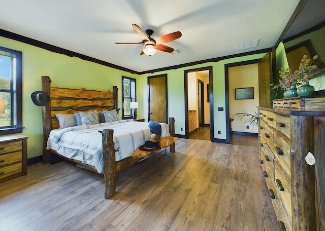 bedroom with ceiling fan, crown molding, wood-type flooring, and a textured ceiling