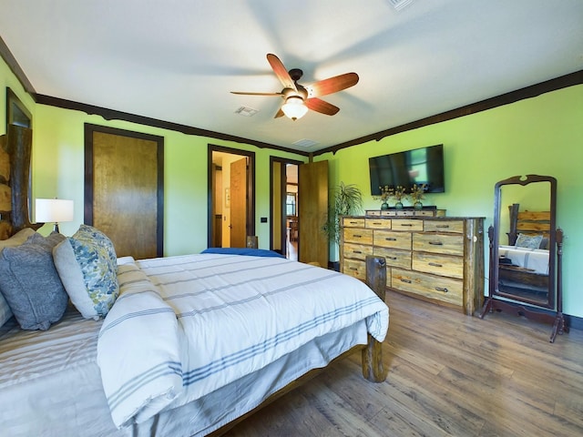 bedroom with hardwood / wood-style floors, ceiling fan, and ornamental molding