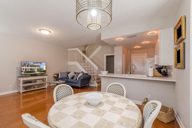 dining space with hardwood / wood-style flooring, sink, and a textured ceiling