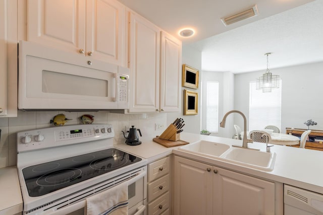 kitchen featuring decorative backsplash, pendant lighting, white appliances, and sink