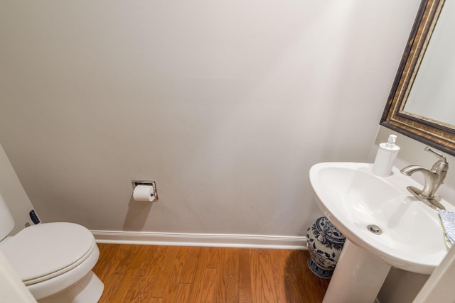 bathroom with hardwood / wood-style floors, toilet, and sink