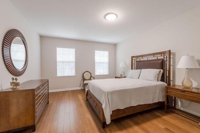 bedroom featuring a textured ceiling and light hardwood / wood-style floors