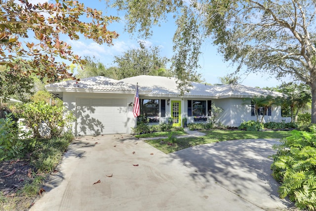 ranch-style home featuring a garage and a front lawn