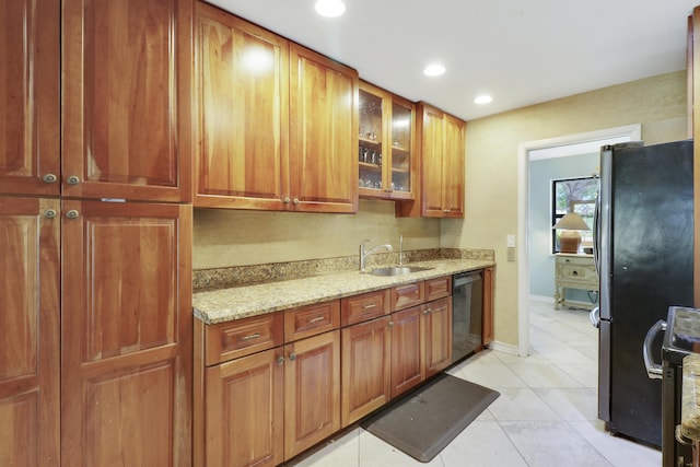 kitchen featuring dishwasher, refrigerator, sink, light tile patterned floors, and light stone counters