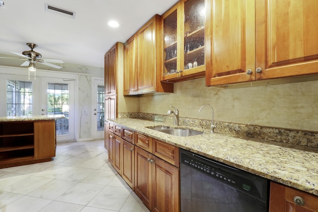 kitchen featuring light stone counters, ceiling fan, sink, light tile patterned floors, and black dishwasher