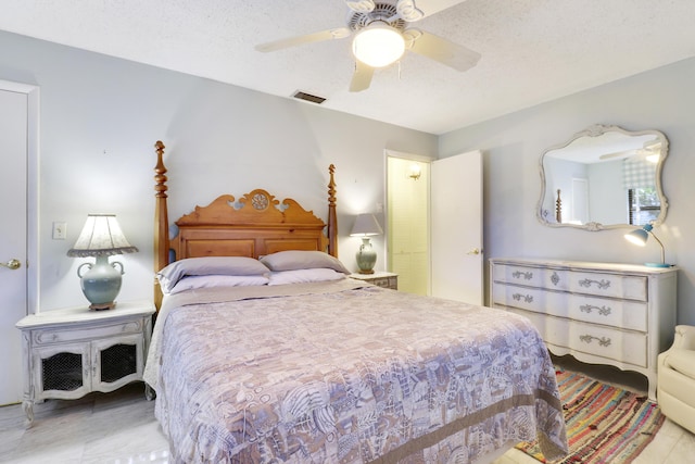 bedroom with ceiling fan and a textured ceiling