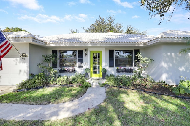 ranch-style home featuring a garage and a front lawn