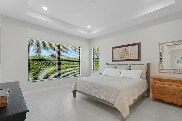 bedroom featuring a raised ceiling and light tile patterned floors