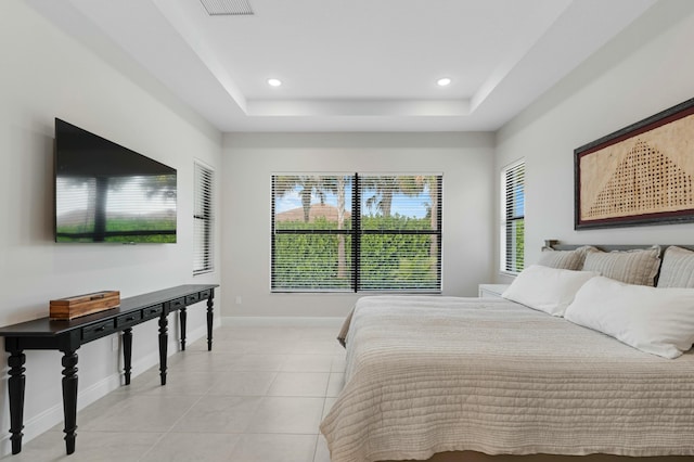 bedroom featuring light tile patterned floors and a tray ceiling