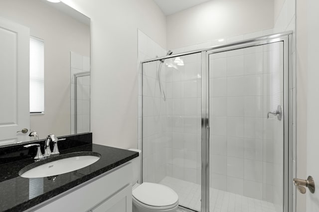 bathroom featuring toilet, vanity, and walk in shower