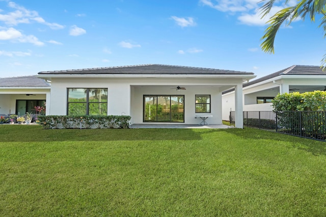 back of property featuring a lawn and ceiling fan