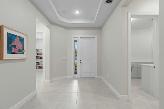 tiled entrance foyer featuring a raised ceiling