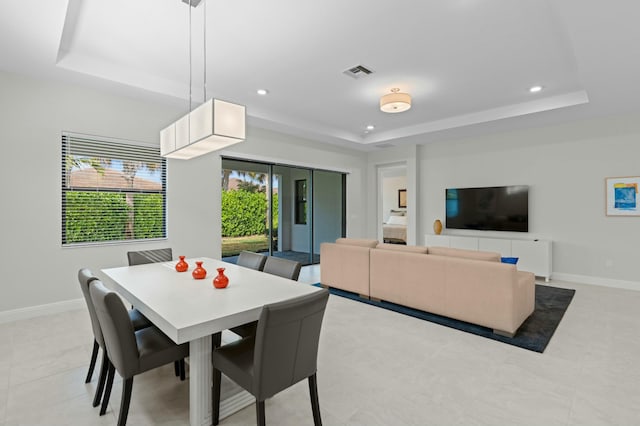 dining room with a healthy amount of sunlight and a tray ceiling