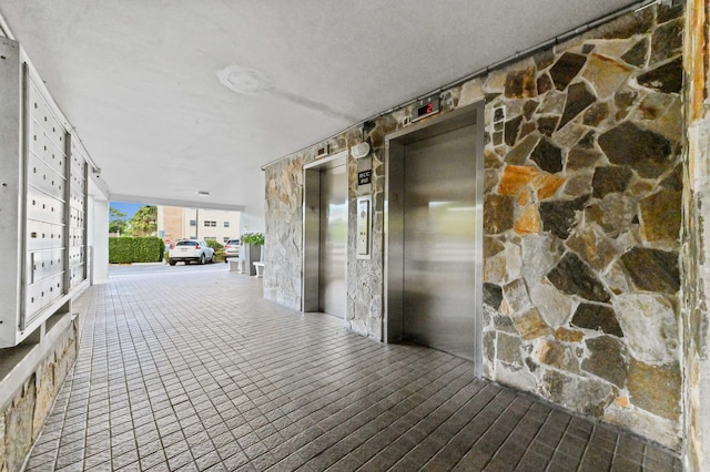 corridor featuring mail boxes and elevator