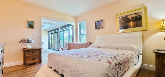 bedroom with hardwood / wood-style floors and access to exterior