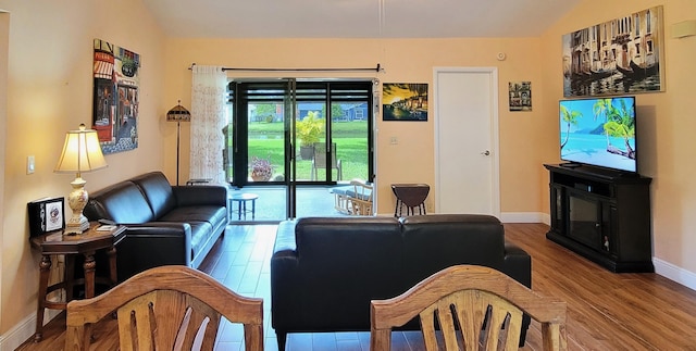 living room featuring hardwood / wood-style flooring and vaulted ceiling