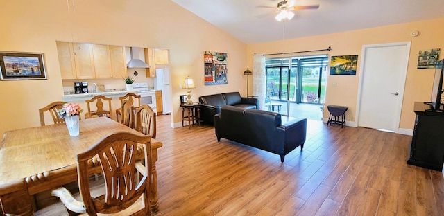 living room featuring ceiling fan, light hardwood / wood-style floors, and lofted ceiling