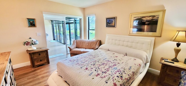 bedroom featuring access to exterior and hardwood / wood-style floors