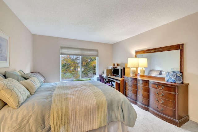 bedroom with a textured ceiling and light carpet