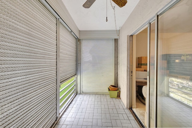 unfurnished sunroom with ceiling fan