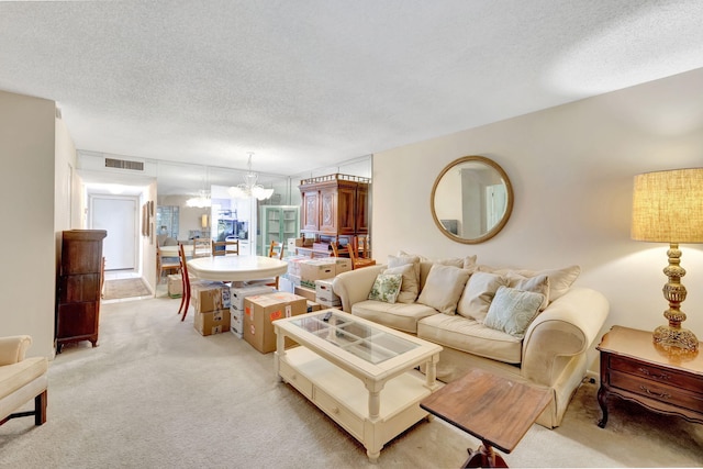 carpeted living room featuring a textured ceiling and an inviting chandelier