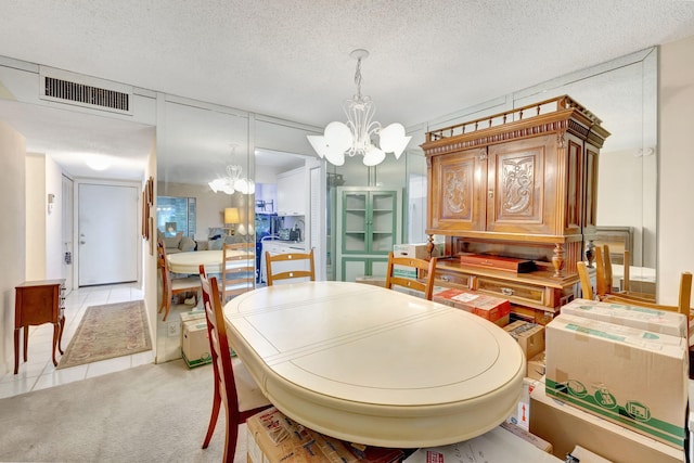 tiled dining area with a notable chandelier and a textured ceiling