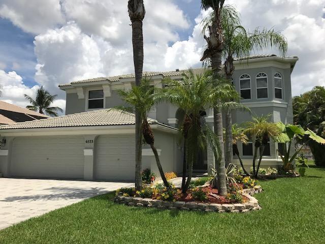 mediterranean / spanish-style house featuring a garage and a front lawn