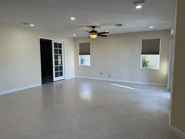 tiled empty room with a wealth of natural light and ceiling fan